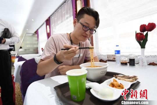 图为旅客在列车上享用正宗牛肉面?！⊙钛廾?摄