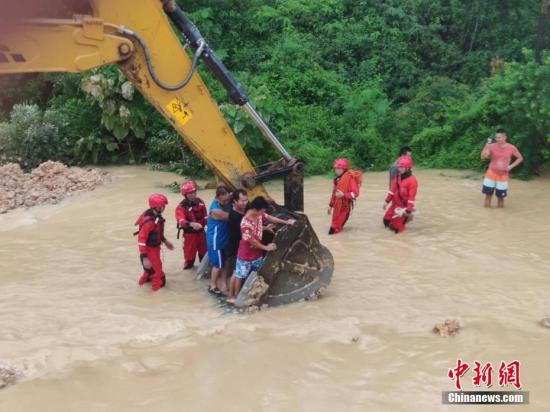 6月16日，因遭遇暴雨袭击，广西沿海多处发生严重内涝，居民被困。当地消防部门接到求助信息后，先后转移被困的居民数十人。图为利用铲车运送被困居民。