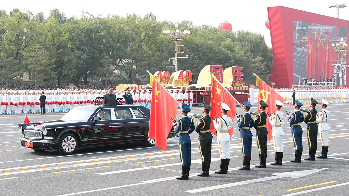 习近平驱车行进至党旗、国旗、军旗前，向旗帜行注目礼